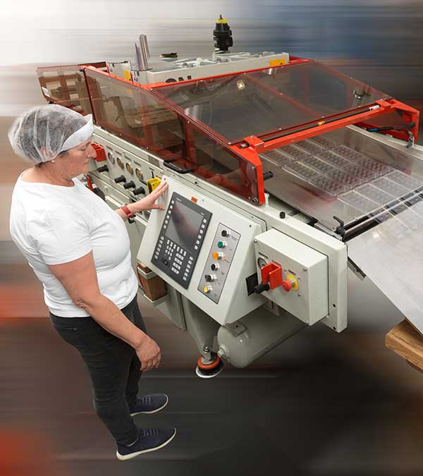 Frau arbeitet an Tiefziehmaschine